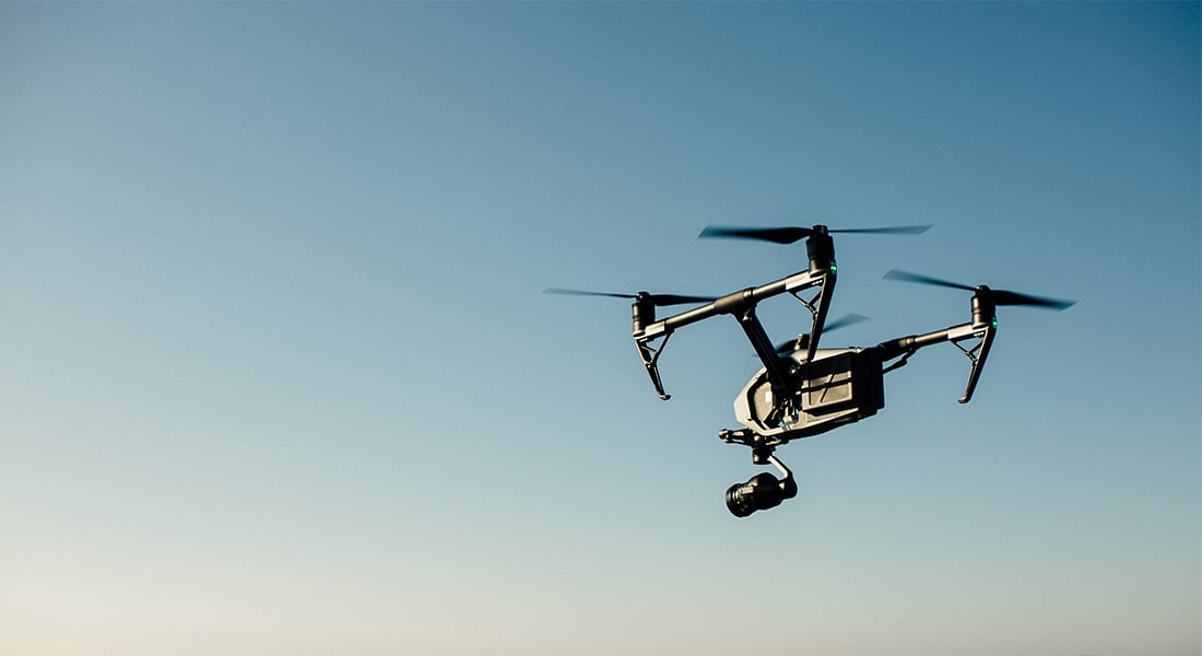 En sort drone der flyver højt oppe i himlen